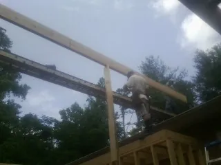Carpenter setting a ridge beam over a new addition frame — Ice Dam Removal by Roofing Brothers in Elmore