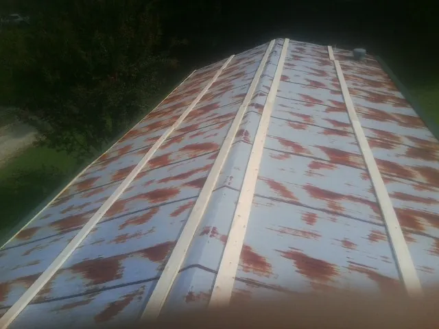 Rusted metal roof panels with new wood purlins before replacement — Storm Damage Roof Repair in Elmore by Roofing Brothers