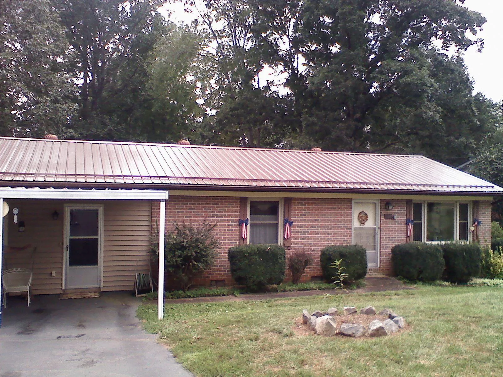 Bronze metal roof and carport on a brick ranch home — Roof Repair work by our crew in Elmore